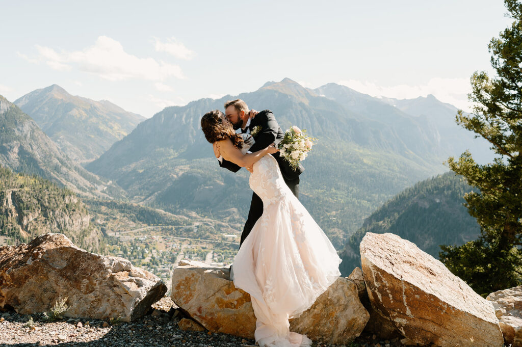 A Colorado intimate wedding couple kisses on an Ouray overlook at Gold Mountain Ranch. 