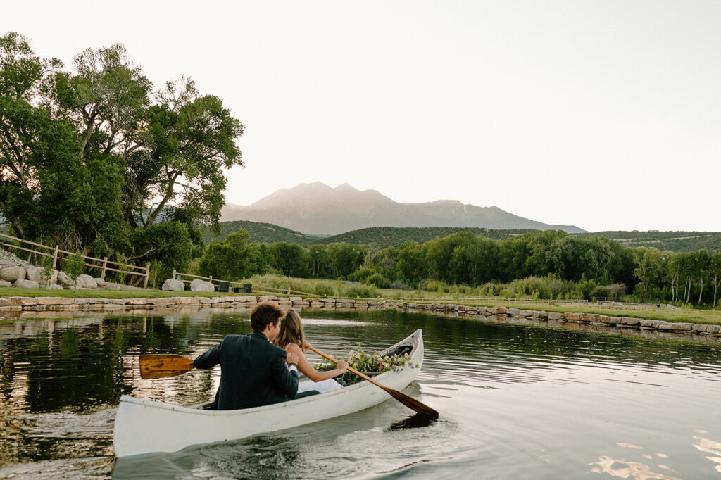 A couple celebrate their Colorado wedding on a pond at Shaw's River Ranch. 