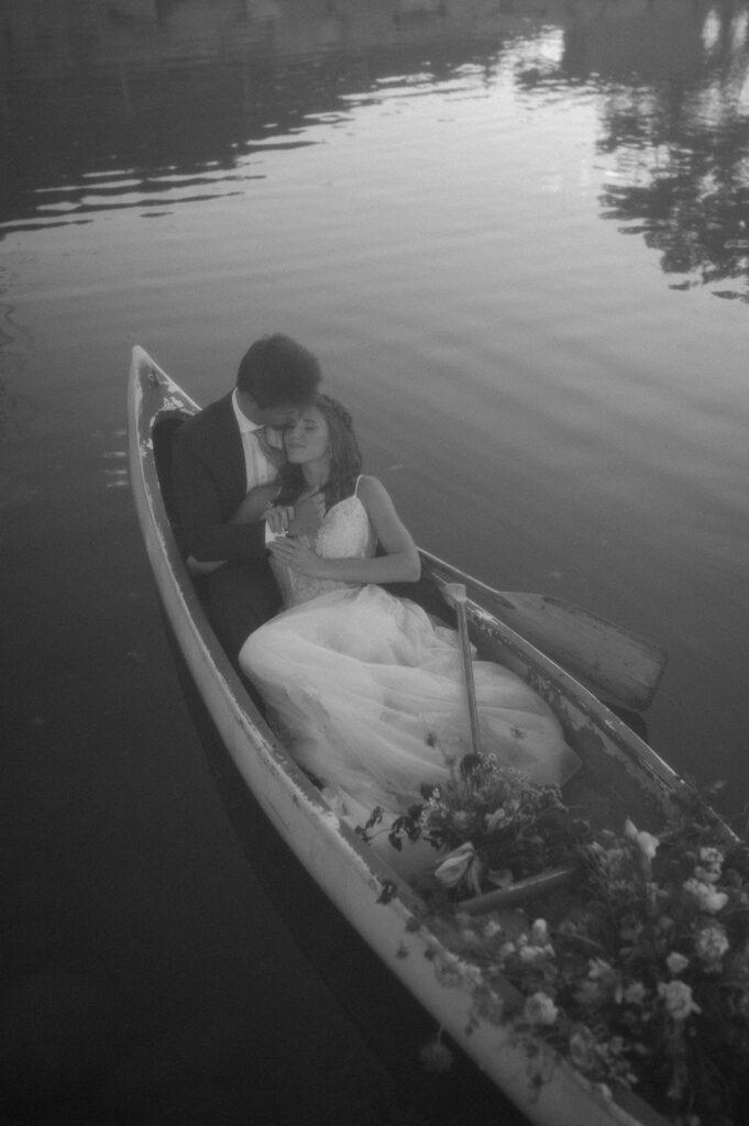 A mountain elopement couple sit in a row boat on a pond during their wedding at Shaw's River Ranch.