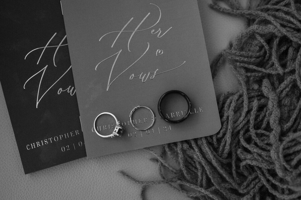 A detail photo of vows books and wedding rings. 