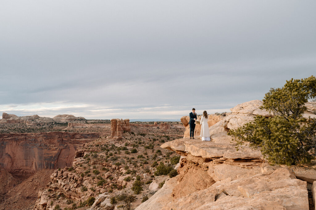 A couple exchanges vows in Canyonlands National Park on an overlook at Sunset. 