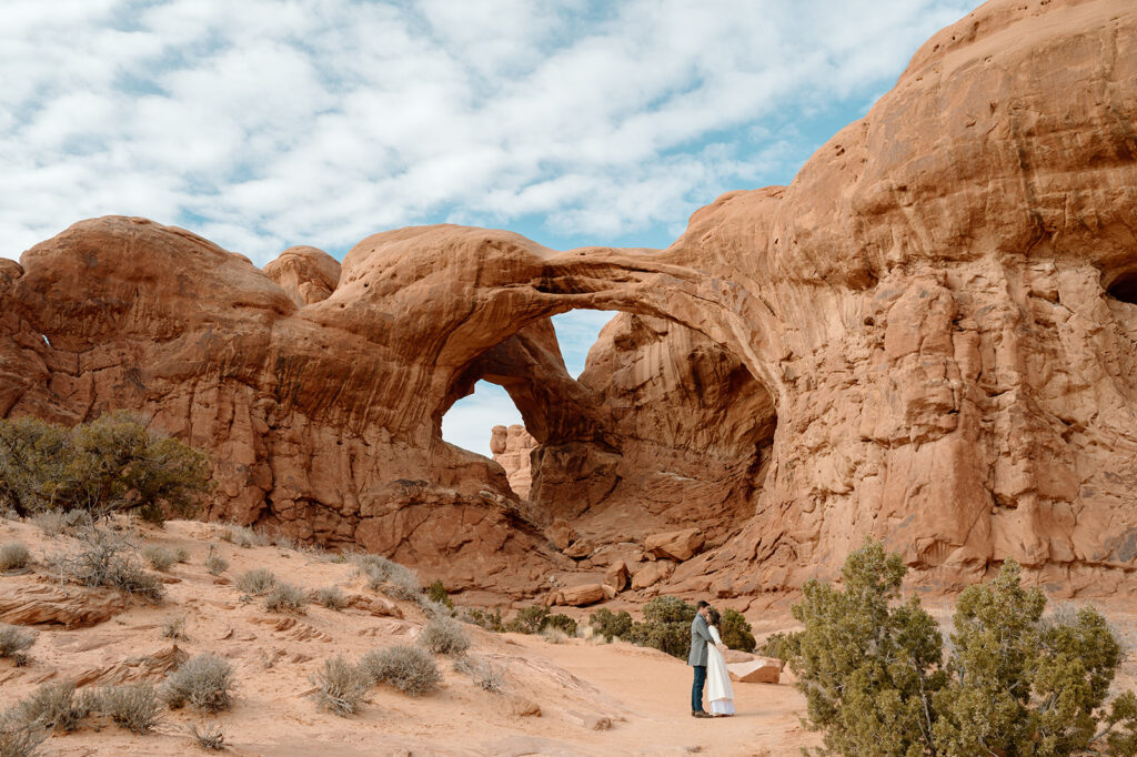 A couple embraces in Arches National Park during their Moab elopement. 