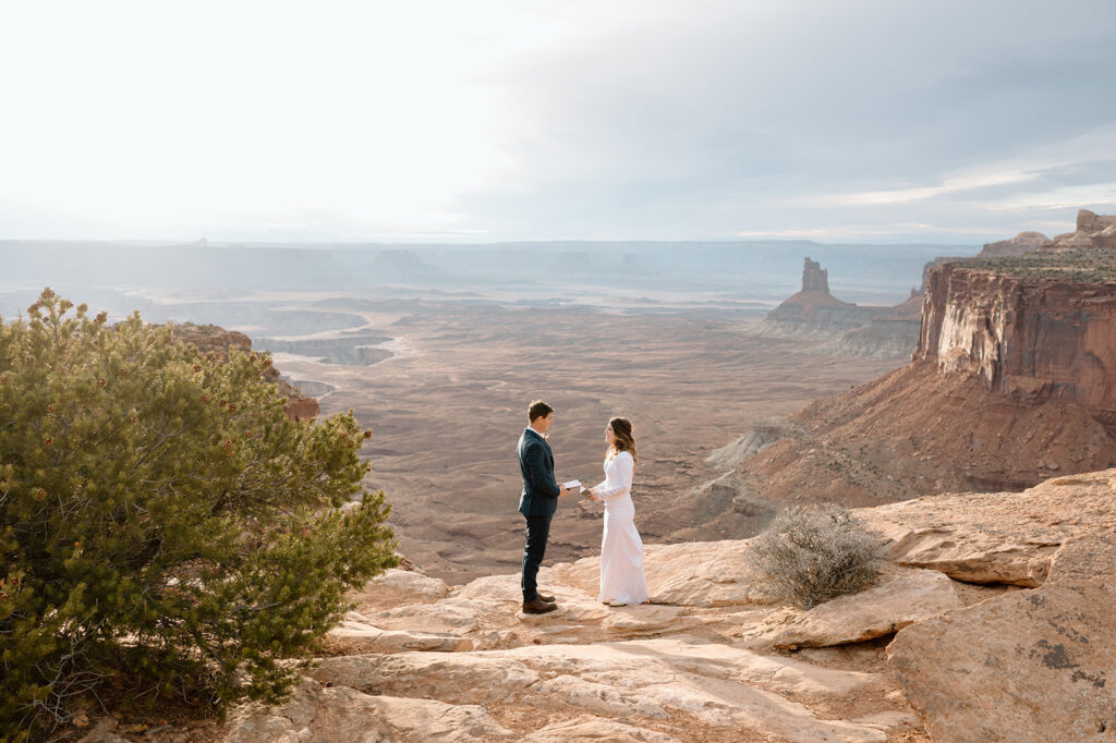 An adventure elopement couple exchanges vows at Grand View Point Overlook during their Utah elopement.