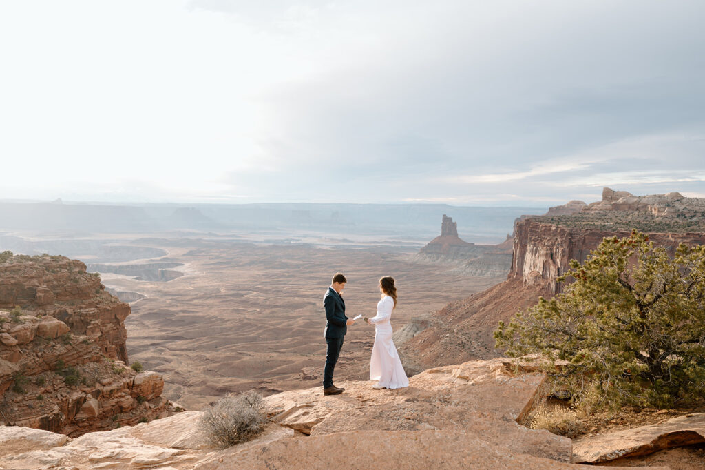 A Utah elopement couple recites intimate vows during a Moab ceremony at Sunset.  