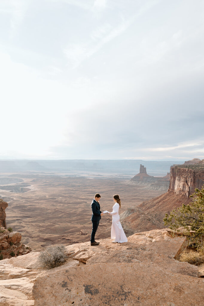 A couple recites vows on Grand View Point Overlook during their Canyonlands elopement. 