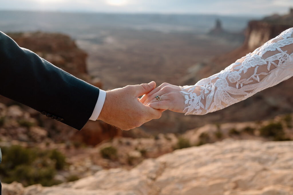 A couple holds hands during their Moab elopement in Canyonlands National Park. 