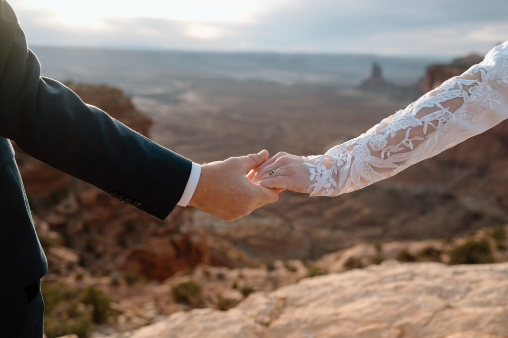 A couple holds hands during their Canyonlands elopement in Moab. 