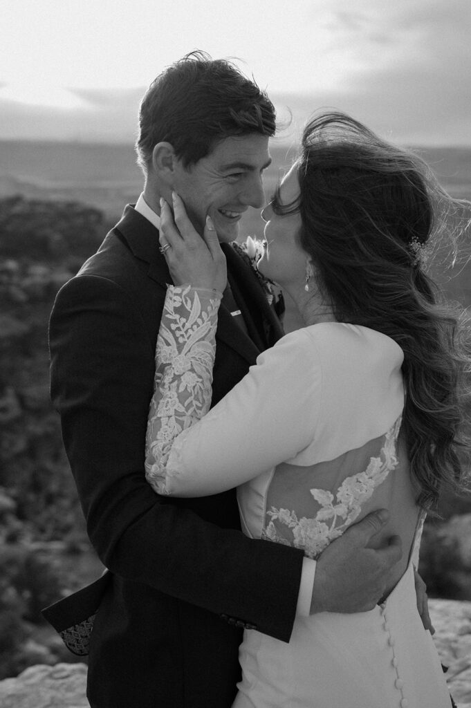 A Moab elopement couple embraces on an overlook during Sunset in Canyonlands National Park. 