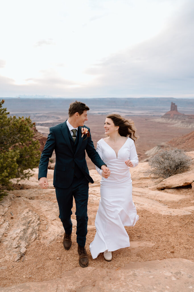 A couple walks along an overlook in Canyonlands National Park during their Moab elopement. 