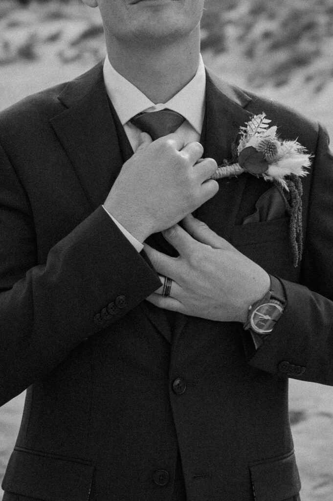 A groom adjusts his tie during his Utah elopement in Moab. 